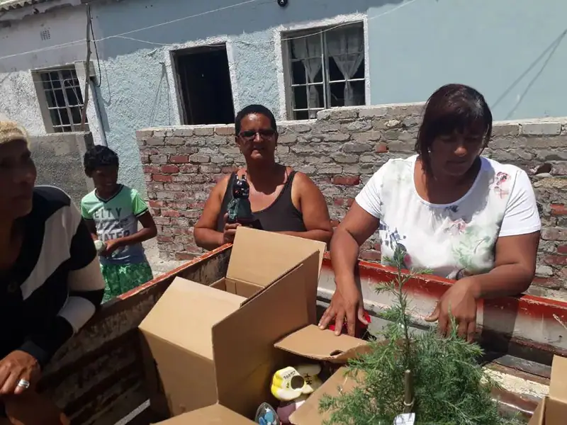 Hangberg Dreams team members handing out donations outdoors