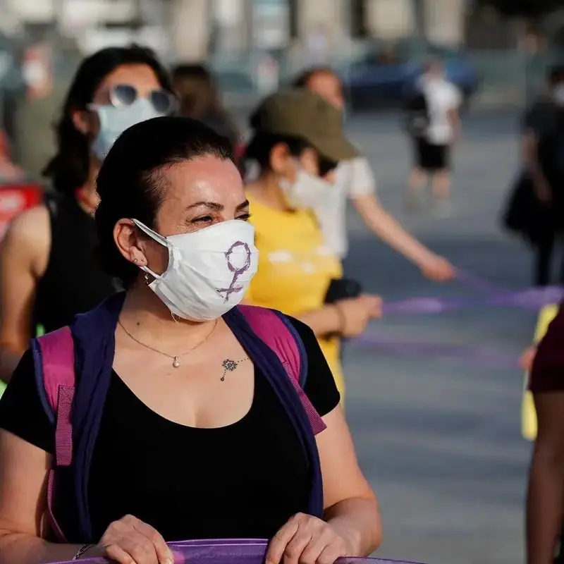A woman in a face mask at a group gathering