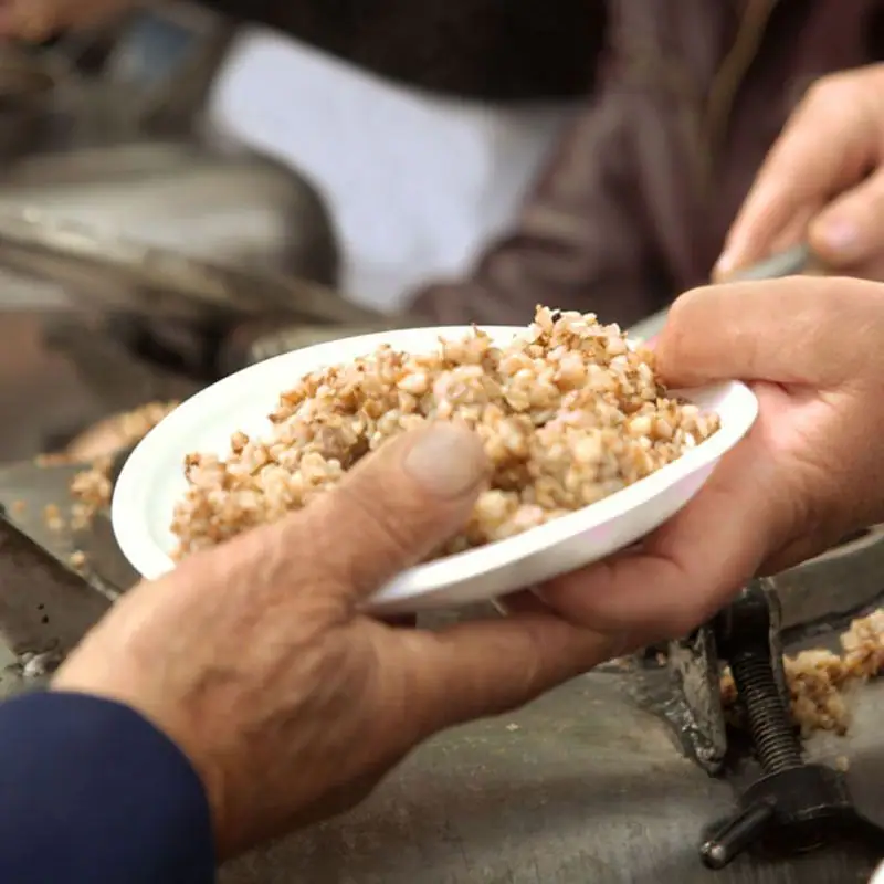 Hands sharing a plate of food