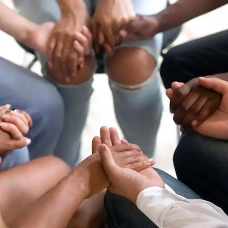 People holding hands in a group therapy session